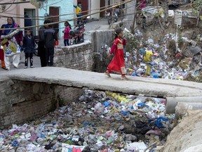 FILE - In this Dec. 25, 2016, file photo, a Pakistani Christian girl crosses a bridge in poor Christian neighborhood in Islamabad, Pakistan.The uproar surrounding Aasia Bibi _ a Pakistani Christian woman who was acquitted of blasphemy charges and released from death row but remains in isolation for her protection _ has drawn attention to the plight of the country's Christians.The minority, among Pakistan's poorest, has faced an increasingly intolerant atmosphere in this Muslim-majority nation where radical religious and sectarian groups have become more prominent in recent years.