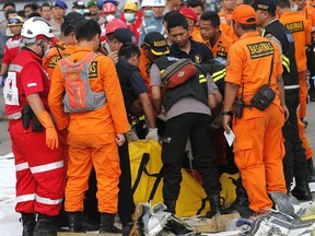 Rescuers inspect a body bag containing the remains of the victims of Lion Air plane crash at Tanjung Priok Port in Jakarta, Indonesia, Wednesday, Oct. 31, 2018.