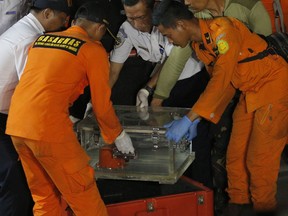 Rescuers carry a box containing the recovered flight data recorder of the Lion Air jet that crashed into the sea on Monday, at Tanjung Priok Port in Jakarta, Indonesia, Thursday, Nov. 1, 2018.
