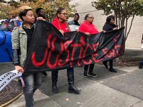 Protesters carry a sign reading “Justice for E.J.” during a protest at the Riverchase Galleria in Hoover, Ala., Saturday, Nov. 24, 2018.