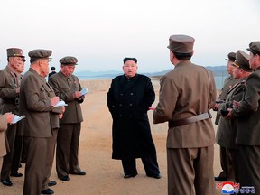 In this undated photo released Friday, Nov. 16, 2018, by the North Korean government, North Korean leader Kim Jong Un, centre, listens to a military official as he inspects a weapon testing at the Academy of National Defence Science, North Korea.