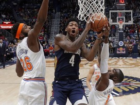 New Orleans Pelicans guard Elfrid Payton goes to the basket between New York Knicks centre Mitchell Robinson and guard Tim Hardaway Jr. in the first half of an NBA game in New Orleans, Friday, Nov. 16, 2018.