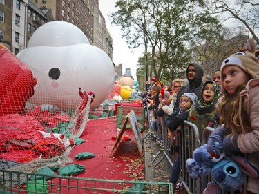 Crowds gather to see giant character balloons being inflated the night before their appearance in the 92nd Macy's Thanksgiving Day parade, Wednesday Nov. 21, 2018, in New York.