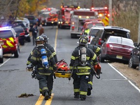 Firefighters carry a stretcher to the scene of a fatal fire at 15 Willow Brook Rd. Tuesday, Nov. 20, 2018, in Colts Neck,N.J.