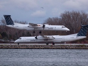 A Porter Airlines plane lands next to a taxiing plane at Toronto's Island Airport on November 13, 2015. Porter Airlines says it hopes it has helped belsnickeling to become a wider Christmas tradition in Nova Scotia.