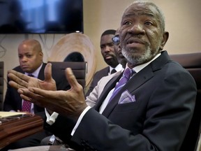 William Charles Blocker, right, one of eight plaintiffs in a lawsuit against Saks Fifth Avenue department store, speaks during a press conference at his lawyer's office, Tuesday Nov. 20, 2018, in New York.