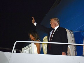 U.S. President Donald Trump and first lady Melania Trump walk down the steps of Air Force One at Palm Beach International Airport in West Palm Beach, Fla., on Tuesday, Nov. 20, 2018. The Trumps are spending the Thanksgiving Day week at his Mar-a-Lago estate in Palm Beach.