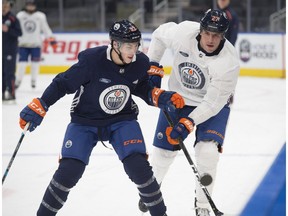 Milan Lucic clears the puck into the offensive zone against Ryan Nugent-Hopkins. The Edmonton Oilers practiced at Rogers Place on Oct. 31, 2018, ahead of their next home game against Chicago.