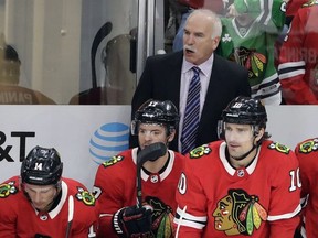 Chicago Blackhawks head coach Joel Quenneville, top, talks to his team during the third period of an NHL hockey game against the Edmonton Oilers, Sunday, Jan. 7, 2018, in Chicago.