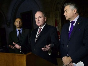 Rob Nicholson, Shadow Minister for Public Services and Procurement, middle, James Bezan, Shadow Minister for National Defence, right, and Richard Martel, Deputy Shadow Minister for National Defence, hold a media availability responding to the Auditor General's report on Canada's fighter jet capability on Parliament Hill in Ottawa on Tuesday, Nov. 20, 2018.