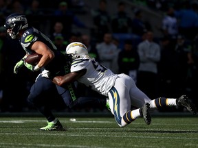 Nick Vannett of the Seattle Seahawks runs with the ball while being tackled by Denzel Perryman of the Los Angeles Chargers in the first quarter at CenturyLink Field on Nov. 4, 2018 in Seattle, Wash.