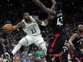 Celtics guard Kyrie Irving passes the ball away with Toronto Raptors forward Pascal Siakam providing the defence last night in Boston. Irving scored 43 points as the Raps lost their third game in a row.