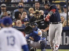In this Oct. 28, 2018, file photo, Boston Red Sox's Steve Pearce, right, hits a home run against the Los Angeles Dodgers during the eighth inning in Game 5 of the World Series baseball game in Los Angeles.