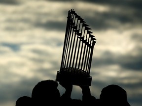 The World Series trophy is hoisted in the air during the 2018 World Series victory parade for the Boston Red Sox on October 31, 2018 in Boston. (Adam Glanzman/Getty Images)