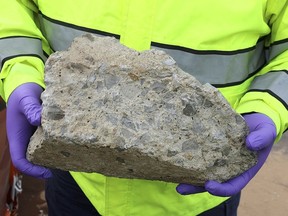 In this photo released by the Nashville Police, an officer holds large piece of concrete that struck a vehicle on Interstate 24, Tuesday, Nov. 20, 2018, in Nashville, Tenn. (Nashville Police via AP)