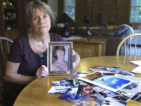 In this Oct. 9, 2018 photo, Linda Marino poses with photographs of her son, Samuel, at her home in Tolland, Conn. Samuel Marino died in a 2009 car crash that relatives believe was intentional after becoming a victim of a male sex trafficking ring. Advocates are calling for more recognition and services for male victims.