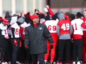 Stampeders head coach Dave Dickenson walks on the field with the team in the background in Calgary on Saturday, November 18, 2017 as they prepare for the CFL western final against the Edmonton Eskimos.