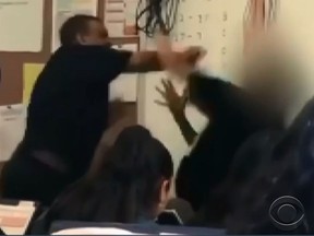 Music teacher Marston Riley, left, allegedly punches a Maywood Academy High School student. (Screen grab)