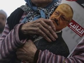 A woman holds a poster during the funeral prayers in absentia for Saudi writer Jamal Khashoggi who was killed last month in the Saudi Arabia consulate, in Istanbul, Friday, Nov. 16, 2018. Turkey's Foreign Minister Mevlut Cavusoglu on Thursday called for an international investigation into the killing of the Saudi dissident Jamal Khashoggi.