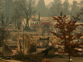 A fire truck drives through an area burned in the wildfire, Tuesday, Nov. 13, 2018, in Paradise, Calif.