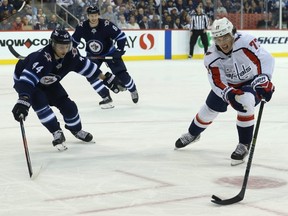 Washington Capitals forward T.J. Oshie (right) corrals a puck with Winnipeg Jets defenceman Josh Morrissey (left) defending in Winnipeg on Wed., Nov. 14, 2018. Kevin King/Winnipeg Sun/Postmedia Network