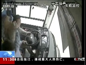 In this image taken from Sunday, Oct. 28, 2018 surveillance video footage run by China's CCTV via AP Video, a passenger strikes a bus driver with an object moments before the bus plunged off a bridge into the Yangtze River in Wanzhou in southwestern China's Chongqing Municipality. Police say a brawl between a passenger and a bus driver was the cause of the bus plunging off a bridge and killing more than a dozen people in southwestern China on Sunday.