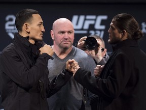 UFC president Dana White (centre) watches as Max Holloway (left) and Brian Ortega stare each other down on Wednesday. ()