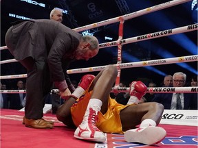 Adonis Stevenson (gold trunk) is being checked out by Marc Gagne after being knocked out by Oleksandr Gvosdyk during their WBC light heavyweight championship fight at the Videotron Center on December 1, 2018 in Quebec City, Quebec, Canada.