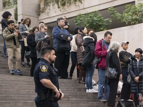 A B.C. Supreme Court sheriff watches over the crowd waiting in line to enter the courtroom to watch the bail hearing for Huawei Technologies CFO Meng Wanzhou on Dec. 10, 2018 in Vancouver.