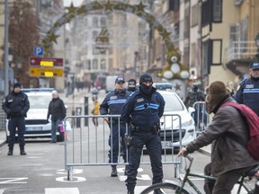 Police officers stand near the Christmas market where the day before a man shot 14 people, killing at least three, on December 12, 2018 in Strasbourg, France. Police have identified the man as Cherif Chekatt, a French citizen on a police terror watch-list. Chekatt exchanged gunfire with soldiers after the attack, is reportedly injured and is still on the loose.