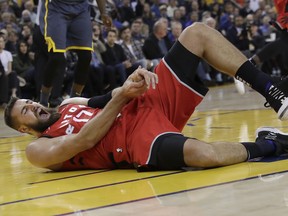 Toronto Raptors center Jonas Valanciunas reacts after injuring his hand on Wednesday night. (AP PHOTO)