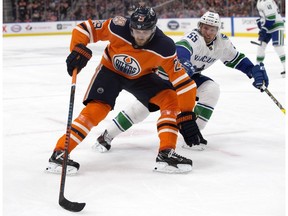 The Edmonton Oilers' Leon Draisaitl battles the Vancouver Canucks' Alex Biega during second period NHL action at Rogers Place, in Edmonton Thursday Dec. 27, 2018.