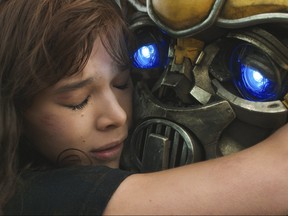 This image released by Paramount Pictures shows Hailee Steinfeld as Charlie and Bumblebee in a scene from "Bumblebee." (Will McCoy/Paramount Pictures via AP)