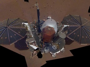 This composite image made available by NASA on Tuesday, Dec. 11, 2018 shows the InSight lander on the surface of Mars. The InSight lander used the camera on its long robotic arm to snap a series of pictures assembled into a selfie. (NASA/JPL-Caltech via AP)