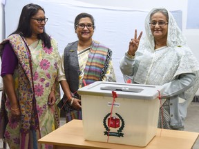 Bangladeshi Prime Minister Sheikh Hasina, right, flashes the victory symbol after casting her vote, as her daughter Saima Wazed Hossain, first from left, and her sister Sheikh Rehana look on at a polling station in Dhaka on December 30, 2018. (AFP/Getty Images)