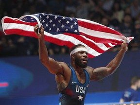 In this Aug. 26, 2017 file photo, United States' Jordan Burroughs celebrates after defeating Khetik Tsabolov of Russia during the final of the Wrestling World Cup at the Paris Bercy Arena, in Paris, France. (AP Photo/Christophe Ena, File)