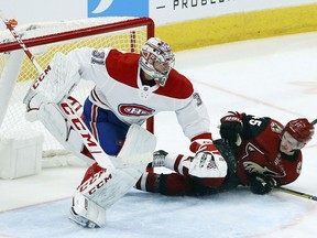 Montreal Canadiens goaltender Carey Price (31) jumps out of the way as Arizona Coyotes right wing Josh Archibald (45) slides into the goal Thursday, Dec. 20, 2018, in Glendale, Ariz. (THE CANADIAN PRESS/AP/Ross D. Franklin)