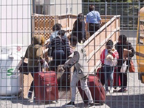 A group of asylum seekers arrive at the temporary housing facilities at the border crossing in St. Bernard-de-Lacolle, Que., on May 9, 2018.