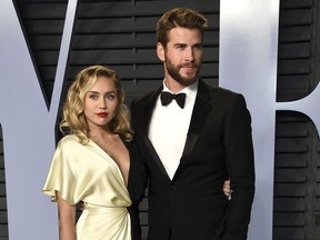 In this March 4, 2018 file photo, Miley Cyrus, left, and Liam Hemsworth arrive at the Vanity Fair Oscar Party in Beverly Hills, Calif. T