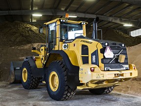 A front end loader is seen with a warehouse full of sand. (Postmedia photo)