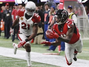 This Dec. 16, 2018, file photo shows Atlanta Falcons wide receiver Julio Jones, right, catching a touchdown pass past Arizona Cardinals cornerback Patrick Peterson during the first half of a NFL football game in Atlanta.