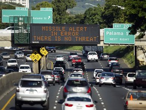 In this Jan. 13, 2018, file photo provided by Civil Beat, cars drive past a highway sign that says "MISSILE ALERT ERROR THERE IS NO THREAT" on the H-1 Freeway in Honolulu. (Cory Lum/Civil Beat via AP, File)