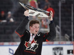 Canada's Alexis Lafreniere hoists the Hlinka Gretzky Cup following the Hlinka Gretzky Cup gold medal game against Sweden, in Edmonton on Saturday, Aug. 11, 2018.