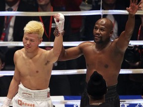 Floyd Mayweather Jr., right, holds the hand of Japanese kickboxer Tenshin Nasukawa, after beating him in their three-round exhibition match on New Year's Eve, at Saitama Super Arena in Saitama, north of Tokyo, Monday, Dec. 31, 2018.