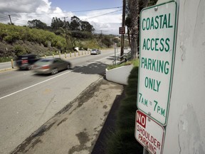 In this April 20, 2007 file photo a sign directing visitors to two parking spaces next at a coastal access gate for Escondido Beach is shown on Pacific Coast Highway in Malibu, Calif.