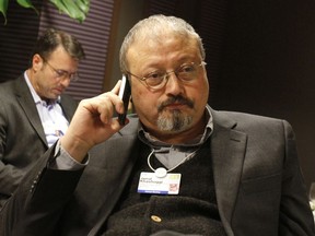 FILE - In this Jan. 29, 2011, file photo, Saudi Arabian journalist Jamal Khashoggi speaks on his cellphone at the World Economic Forum in Davos, Switzerland. Saudi Arabia issued an unusually strong rebuke of the U.S. Senate on Monday Dec. 17, 2018, rejecting a bipartisan resolution that put the blame for the killing of Saudi journalist Jamal Khashoggi squarely on the Saudi crown prince and describing it as interference in the kingdom's affairs.