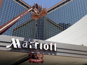 In this Tuesday, April 30, 2013, file photo, a man works on a new Marriott sign in front of the former Peabody Hotel in Little Rock, Ark. (THE CANADIAN PRESS/AP/Danny Johnston, File)