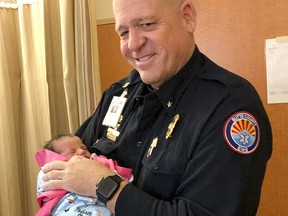 In this photo taken Dec. 14, 2018, paramedic Mickey Huber holds two-day-old baby Zoele Mickey Skinner at Enloe Medical Center in Chico, Calif. (Daniel Skinner via AP)