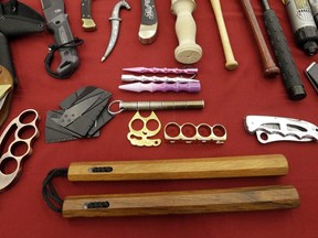 In this April 6, 2017, file photo, objects confiscated from passengers' carry-on luggage, including nunchucks, bottom, are displayed at Seattle-Tacoma International Airport in SeaTac, Wash. A federal court says New York's ban on nunchucks, the martial arts weapon made famous by Bruce Lee but prohibited in the state for decades, is unconstitutional under the Second Amendment.