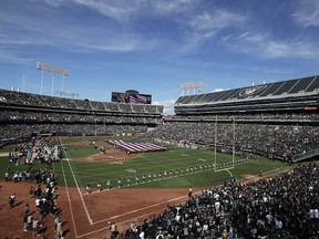 In this Sept. 30, 2018, file photo, a U.S. flag is displayed on the field at Oakland Coliseum during the national anthem in Oakland, Calif. (AP Photo/Jeff Chiu, File)